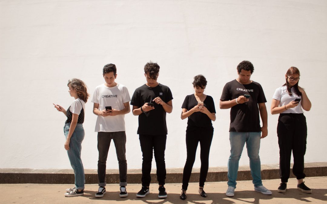Picture of people stood side by side using smartphones