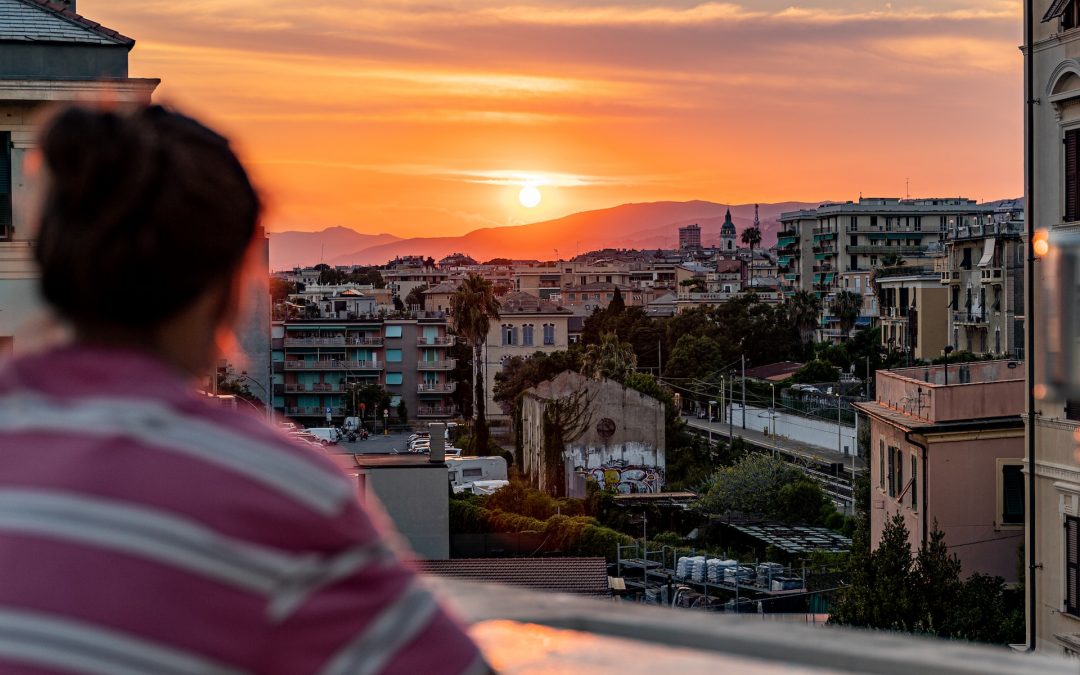 A young people looking out from a rooftop across the City of Genoa, Italy